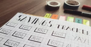 Hand-drawn savings tracker chart on a notebook with labeled amounts for budgeting and saving money.